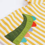 A close up of the Frugi kids wrap around crocodile outfit. Showing the back of the t shirt with the tail of the crocodile applique on yellow and white stripe organic cotton fabric