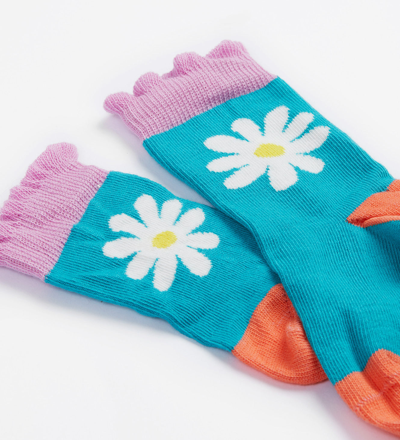 A close up of the Frugi kids Freya sock. Showing the light blue sock with white daisy design and light purple frill on organic cotton fabric.