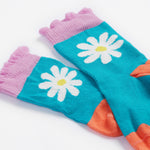 A close up of the Frugi kids Freya sock. Showing the light blue sock with white daisy design and light purple frill on organic cotton fabric.