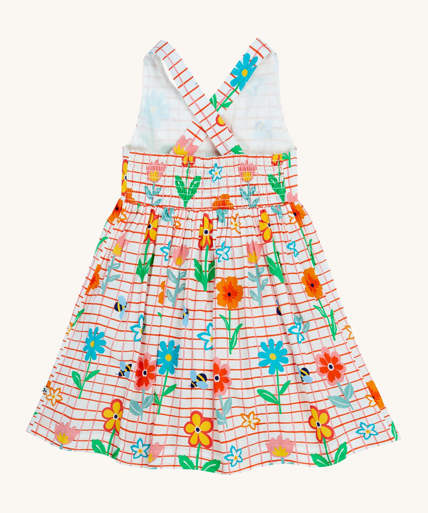 Frugi kids Delpi paint a floral dress - GOTS organic cotton kids dress with white check and red outline, sleeveless with a back strap fasteners the back of the waist band. Features prints of different coloured flowers and bees. 