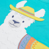 Close up of the Frugi kids easy on llama outfit. Showing the detail of the grey llama wearing a yellow hat with a purple orange and yellow saddle. Features loose cotton threads to represent hair on blue organic cotton fabric