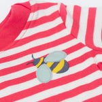 A close up of the t-shirt from the Frugi kids bee stripe outfit. Showing the bee applique with light grey wings on a light pink and white striped organic cotton fabric