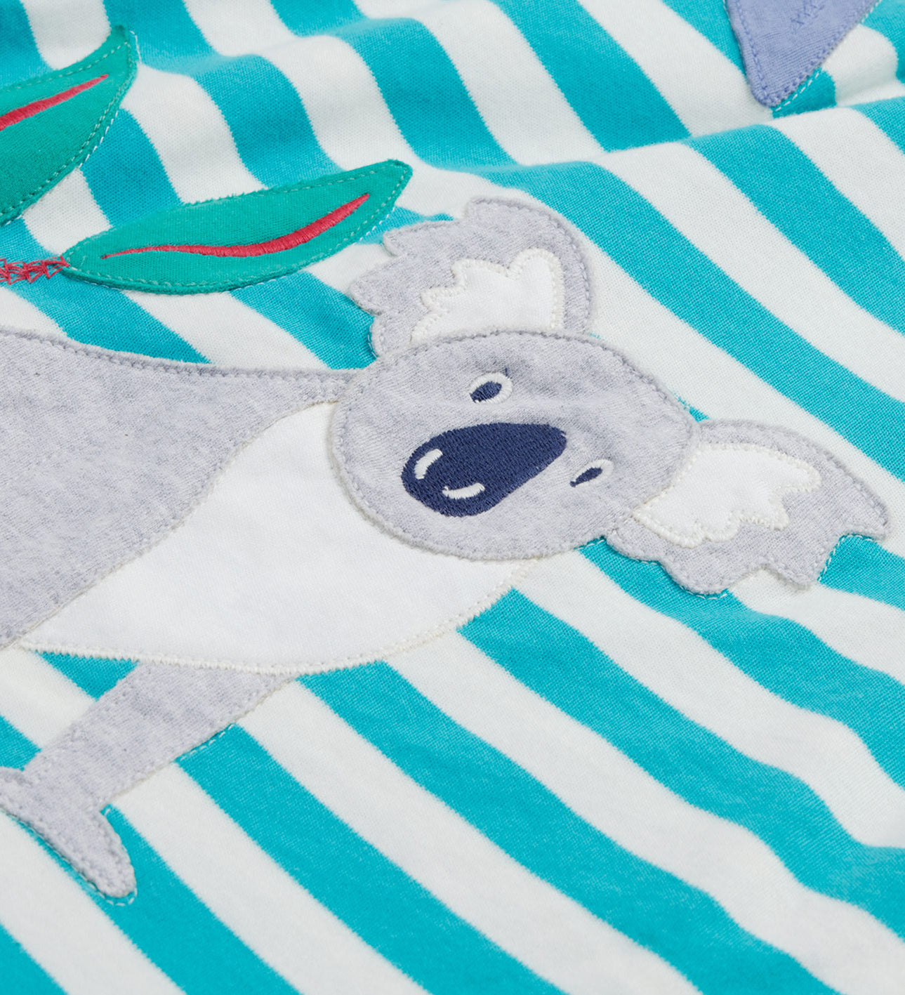 Close up of the Frugi kids Felicity koala dress. Showing the appliqué of a grey koala on white and light blue striped organic cotton fabric