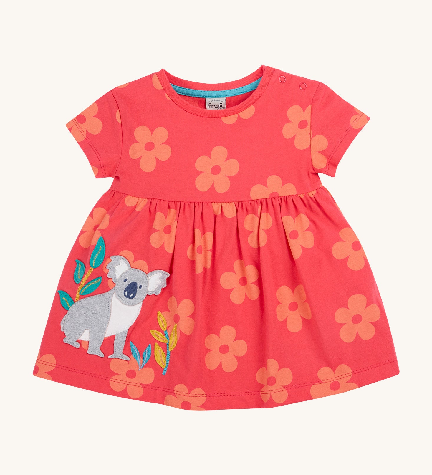 Frugi kids flora fun koala tunic top - GOTS organic cotton kids tunic top in light pink with pastel orange floral prints, short sleeves and popper fasteners on the shoulder for easy fitting. Features and applique of a grey koala next to bamboo shoots.