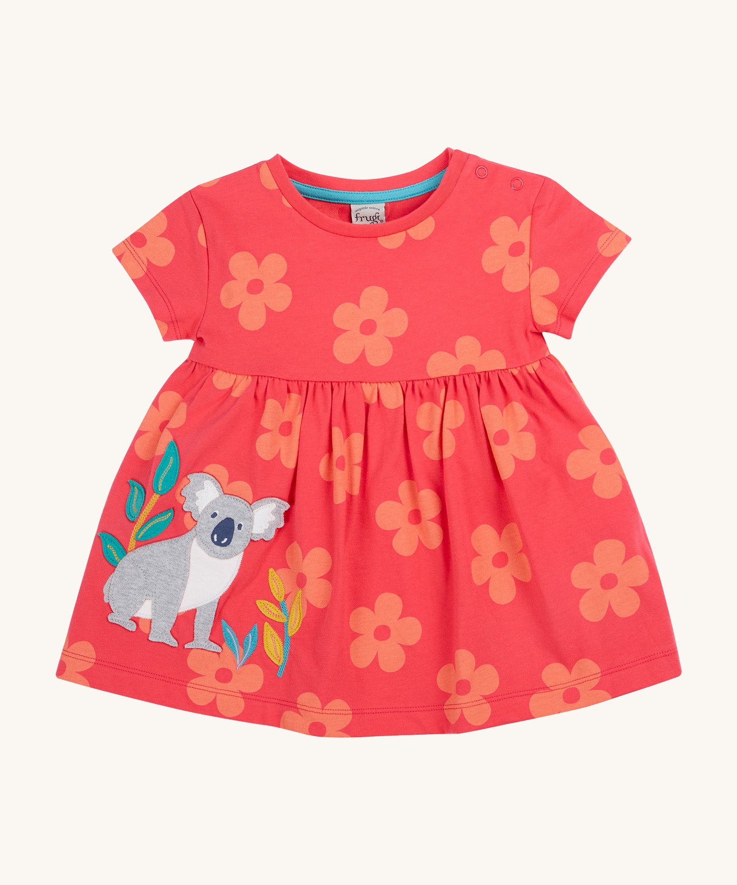 Frugi kids flora fun koala tunic top - GOTS organic cotton kids tunic top in light pink with pastel orange floral prints, short sleeves and popper fasteners on the shoulder for easy fitting. Features and applique of a grey koala next to bamboo shoots.