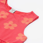 A close up of the Frugi kids summer flamingo / flower dress. Showing the detail neck and sleeve cuffs with the light coral flowers on pink organic cotton fabric