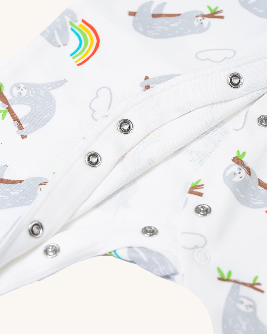 A closer view of the sleeves and cuffs on the Frugi Baby Organic Cotton Lovely Babygrow - Sleepy Sloths. A footed babygrow imade from super soft organic cotton and features adorable sleepy sloths and rainbows all-over print