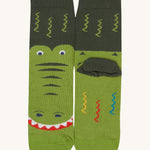 A close up of the Frugi green crocodile sock a soft GOTS cotton sock features a dark green sole panel