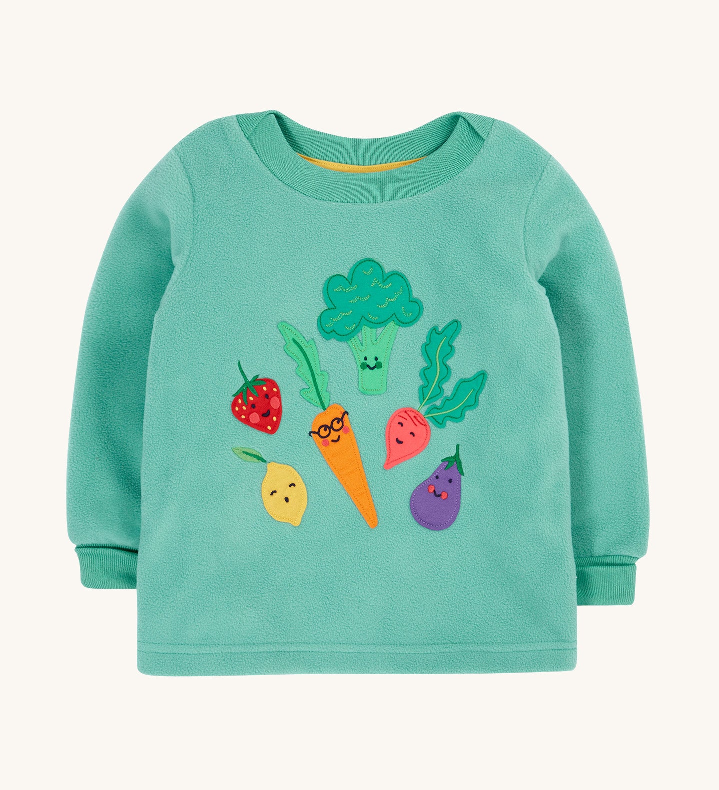 Frugi kids green fleece jumper with veg design on a cream backgroud.