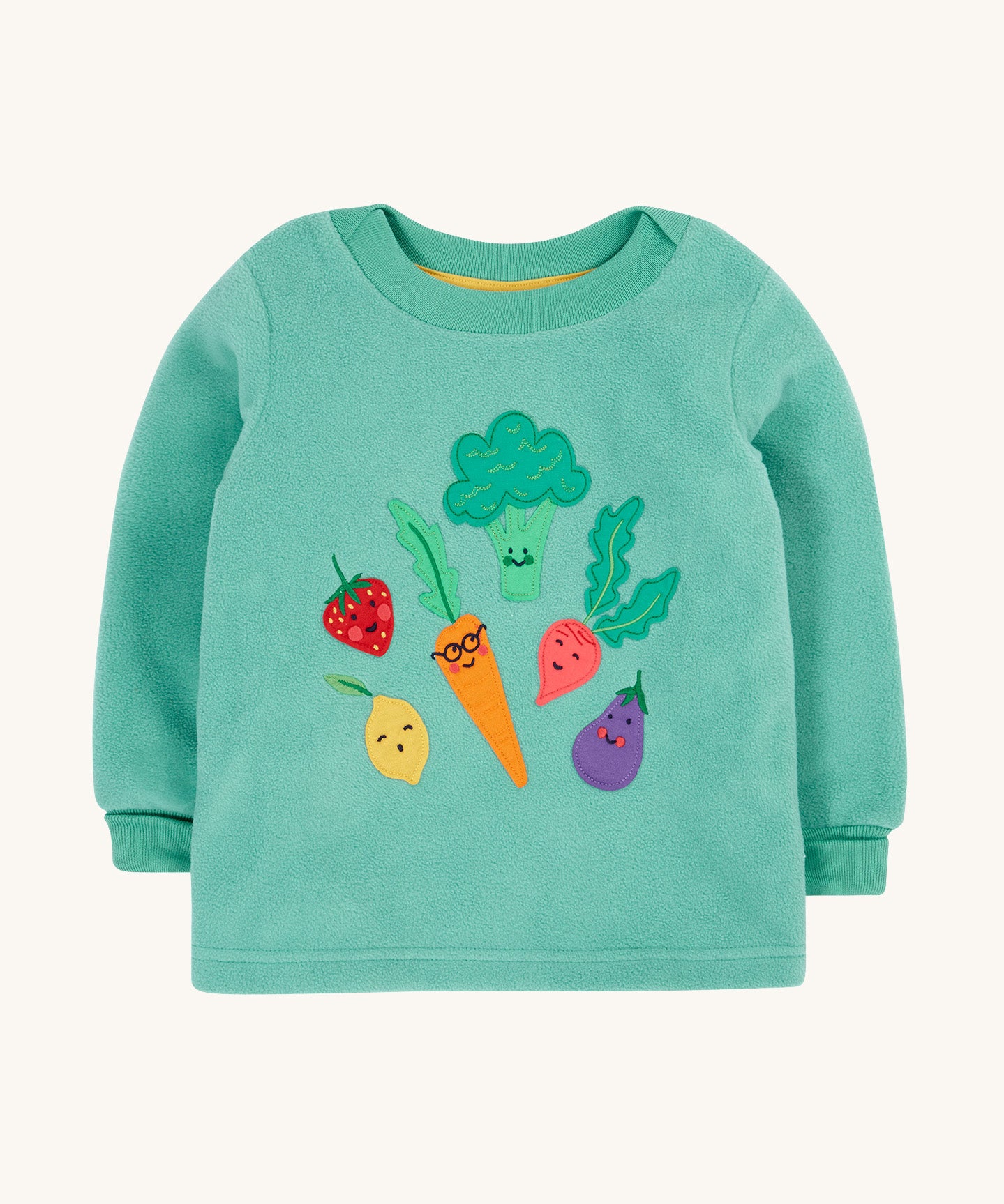 Frugi kids green fleece jumper with veg design on a cream backgroud.