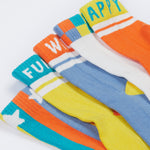 Close up of the Frugi kids have fun sunnie socks 5 pack. Showing the elasticated cuffs with different fun Frugi slogan on vibrant organic cotton fabric.