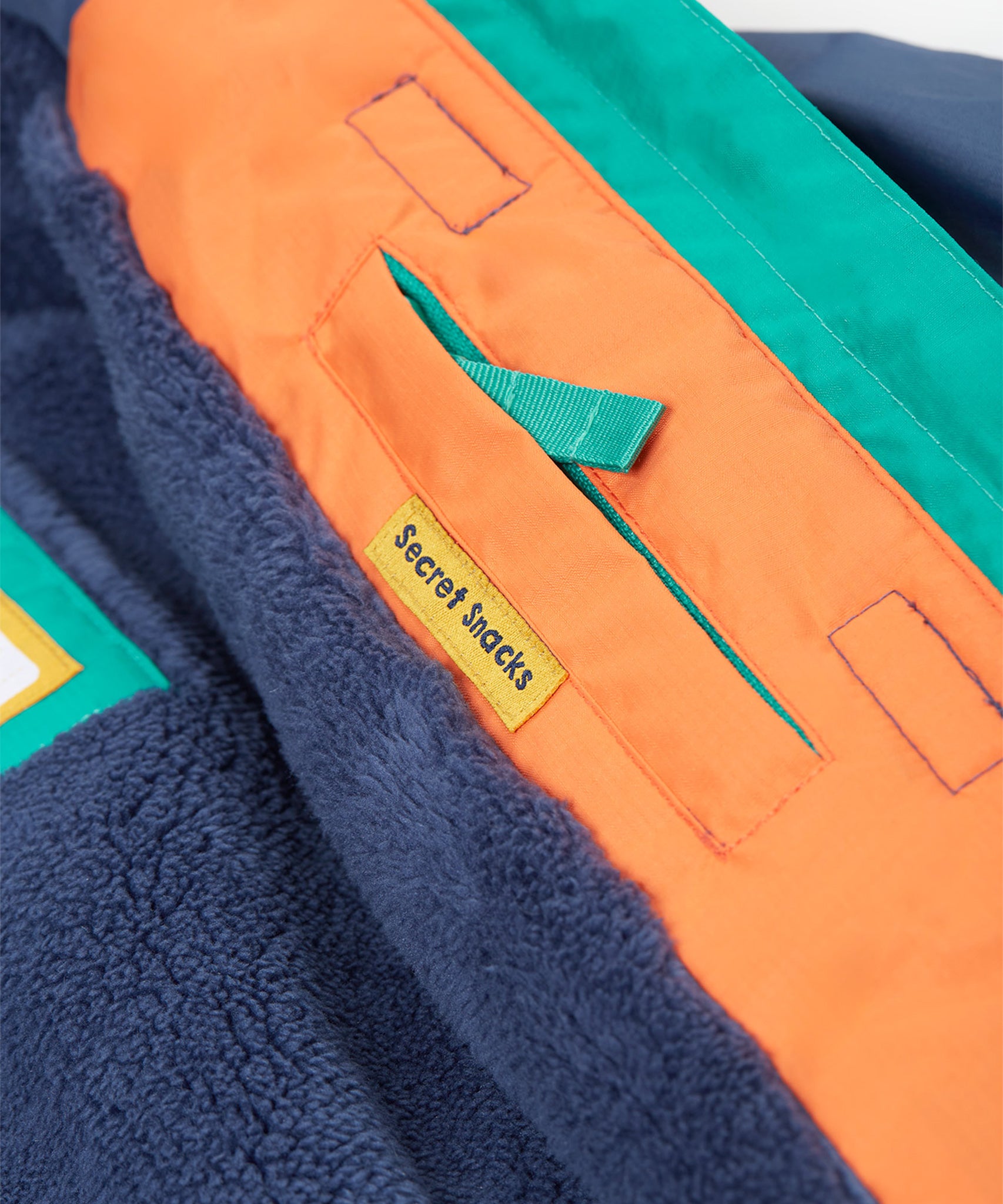 A closer look at the reflective stars on the arms of the Frugi Snow & Ski Coat - Iguana Colourblock