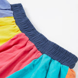 Close up of the Frugi kids rainbow jersey skit showing the navy elasticated waist band and rainbow colour block  panels on organic cotton fabric