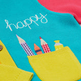 Close up of the Frugi kids Rose pocket cardigan, happy pen pot. Showing the yellow pocket with an applique of pens and pencils with a happy slogan embroidery on organic knitted cotton fabric.