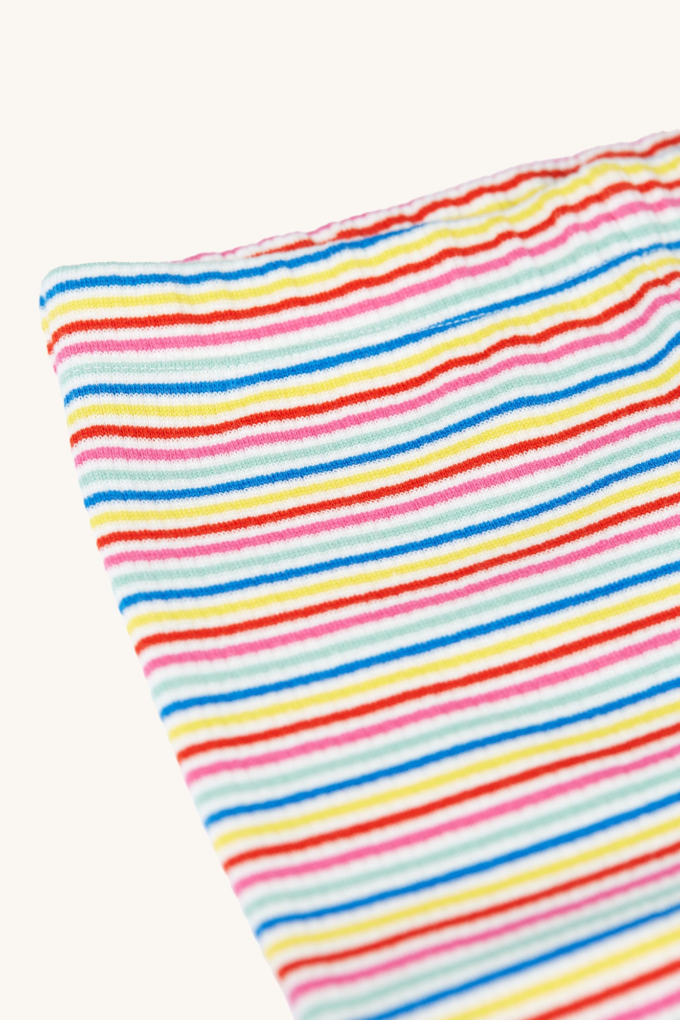 A closer look at the waistband on the Frugi Children's Organic Cotton Laurie Rib Shorts - Rainbow Stripe. Long organic cotton rib cycling shorts for children in white with a colourful rainbow stripe 