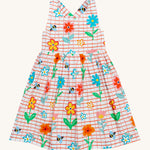 Frugi kids Delpi paint a floral dress - GOTS organic cotton kids dress with white check and red outline, sleeveless with a back strap fasteners. Features prints of different coloured flowers and bees. 