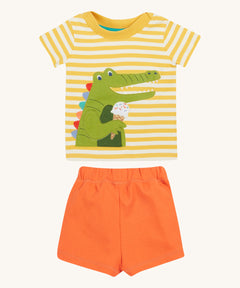 Frugi kids easy wrap around crocodile outfit. GOTS organic cotton Frugi kids outfit with a yellow and white stripe, short sleeve t-shirt, yellow neck trim and orange short. Features a crocodile eating a ice applique on the front of the t-shirt