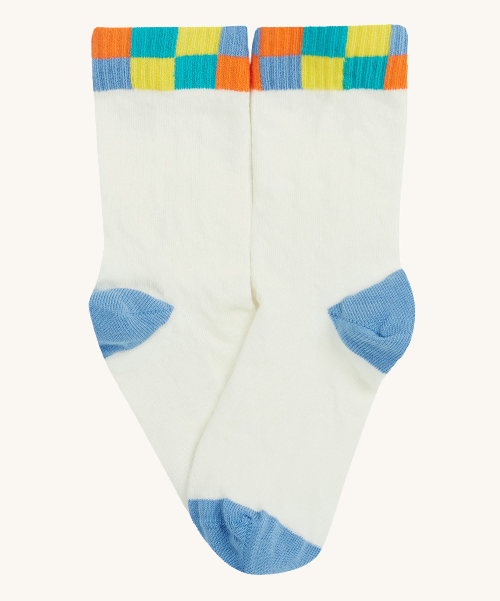 Close up of the Frugi white sunnie socks. Showing the multicoloured check design on the ankle cuff. Features a light blue heel and toe contrast panel on white organic cotton fabric