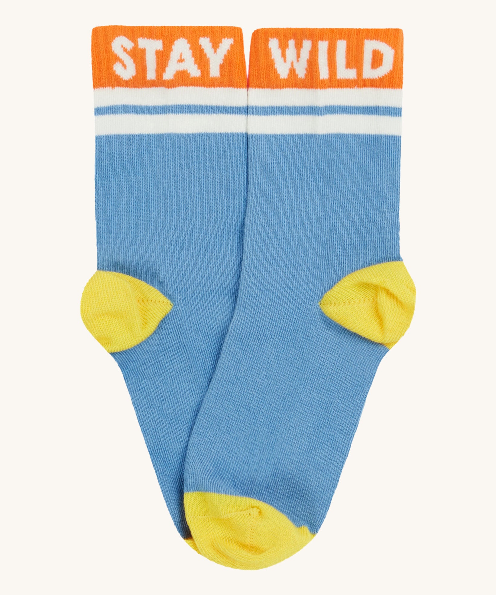 Close up of the Frugi light blue sunnie socks. Showing the 'stay wild' slogan on the orange ankle cuff. Features a light yellow heel and toe contrast panel on light blue organic cotton fabric