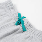 Close up of the Frugi kids jack appliqué joggers - Showing the  turquoise waist drawstring detail on grey organic cotton fabric