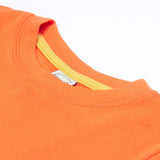 Close up of the Frugi kids orange koala t-shirt. Showing theorange neck trim with light yellow trim on the inside of the neck on orange organic fabric