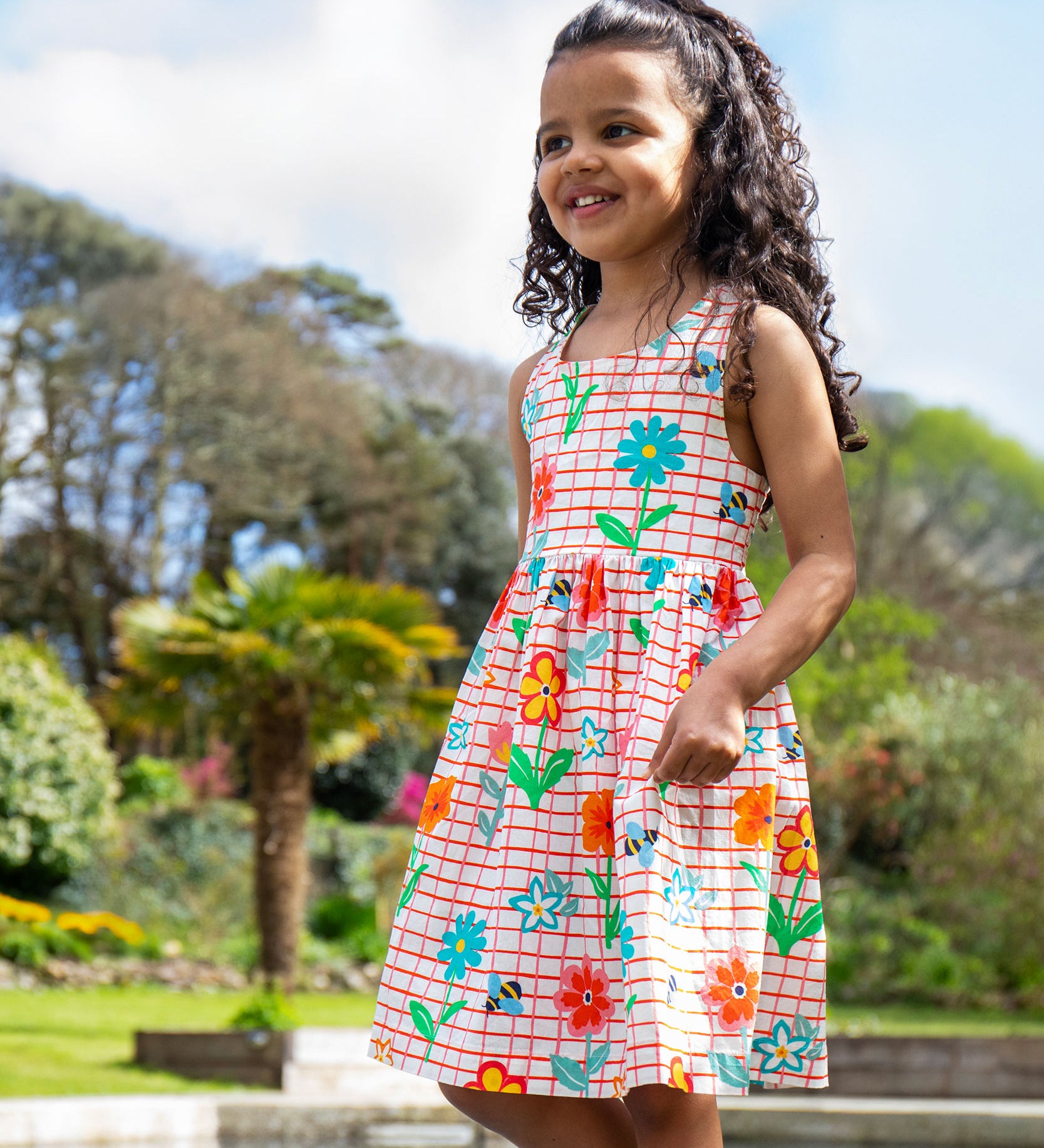 A child wearing the Frugi Kids Paint A Floral Delphi Dress.