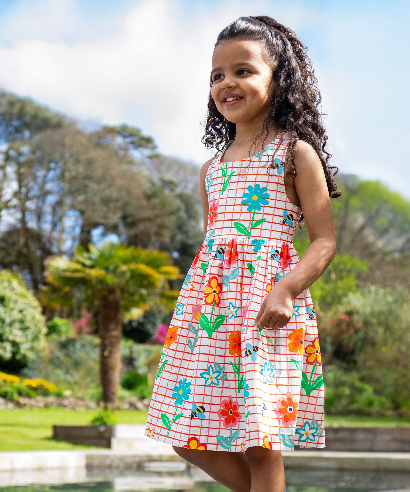 A child wearing the Frugi Kids Paint A Floral Delphi Dress.