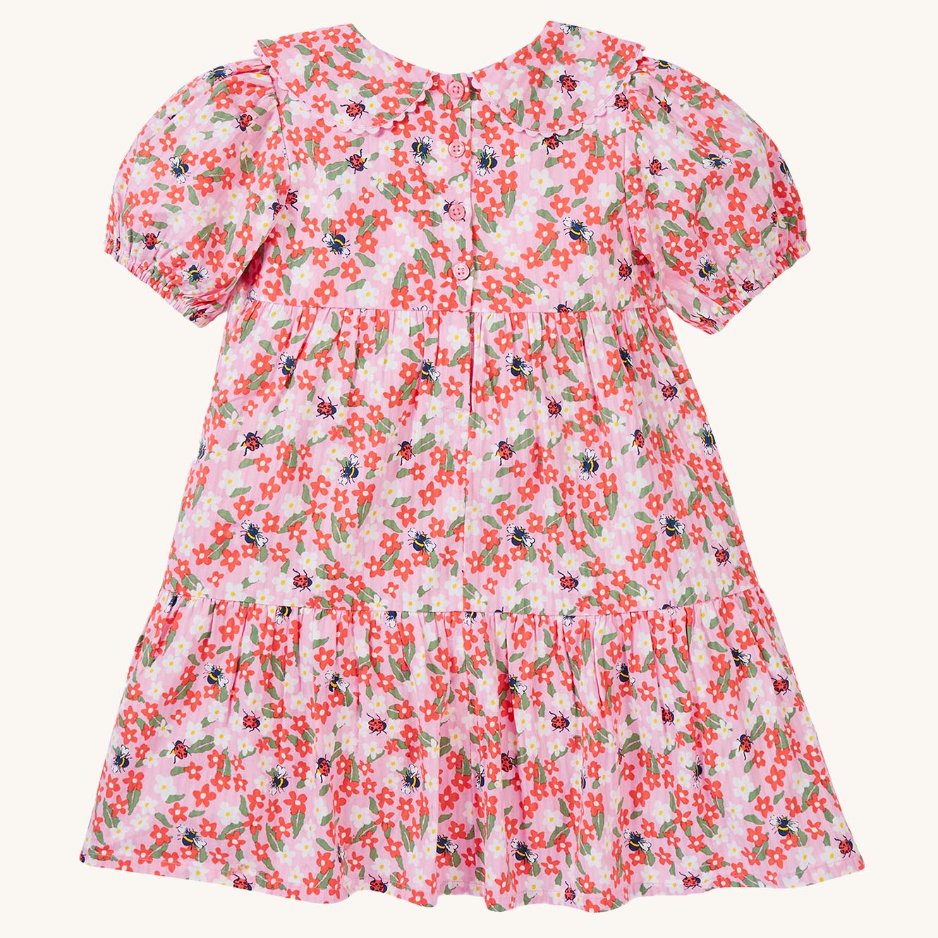  bees and ladybirds on a light pink fabric. The dress is a Tiered Dress with oversized peter pan collar and puff slee