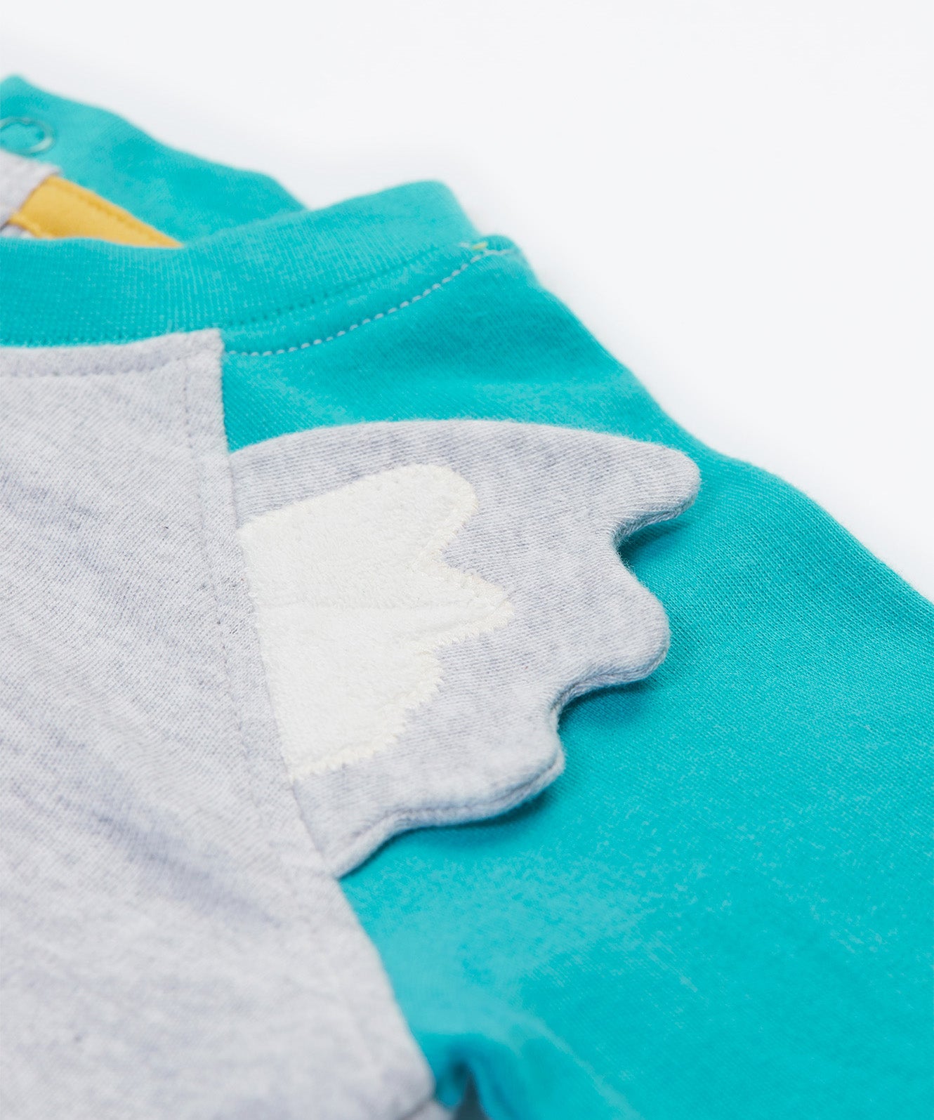 Close up of the Frugi kids koala raglan t-shirt. Showing the grey ears stitched loosely on the front panel on grey and blue organic cotton fabric