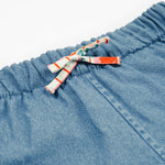 Close up of the frugi marigold reversible shorts, paint a floral / denim - GOTS organic cotton kids reversible shorts showing the denim and waist drawstring detail