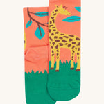 A close up of the Frugi giraffe rock my socks. A light peach sock with a fun giraffe print with leaves on the front and back on organic cotton fabric