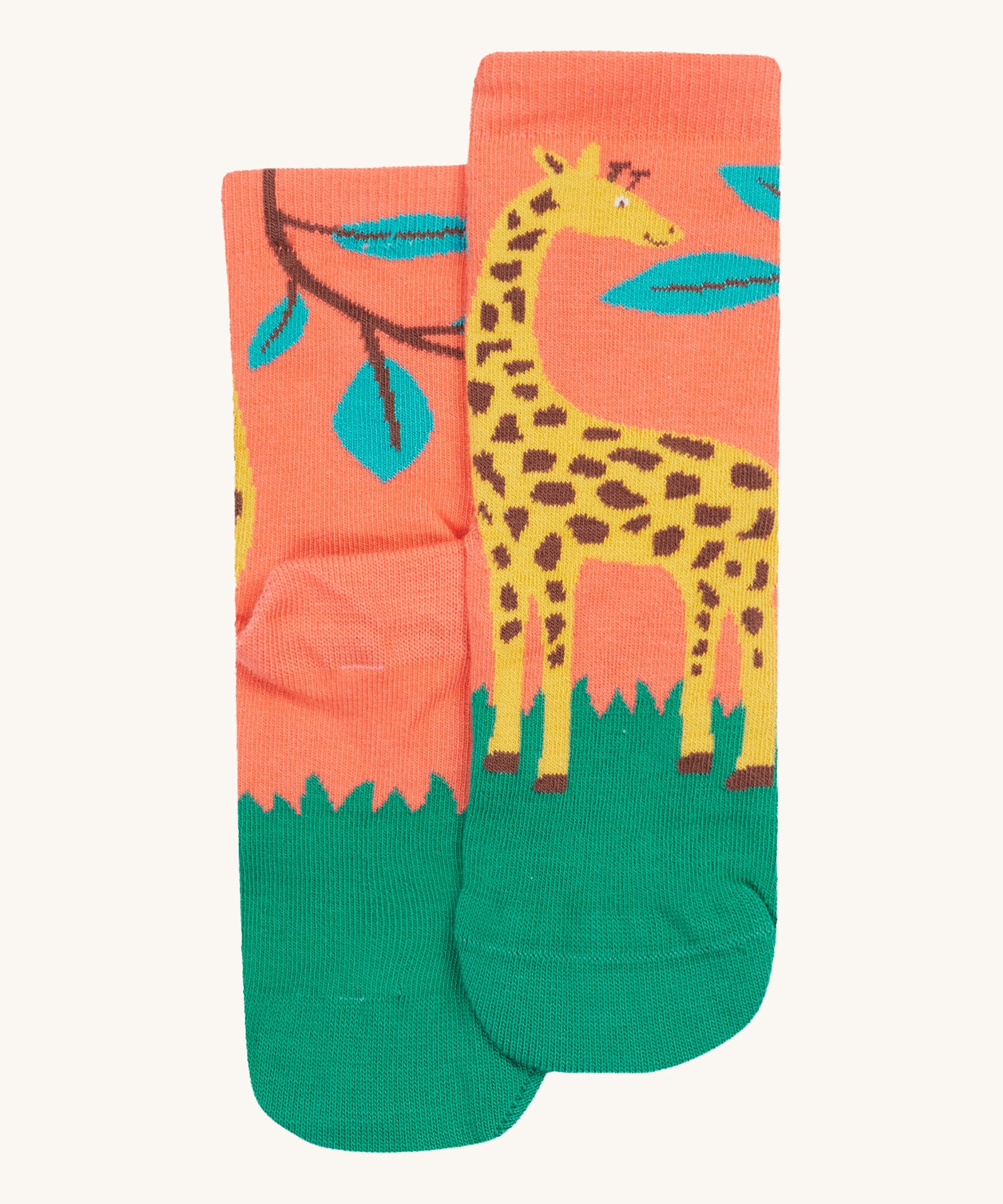 A close up of the Frugi giraffe rock my socks. A light peach sock with a fun giraffe print with leaves on the front and back on organic cotton fabric