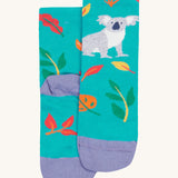 A close up of the Frugi koala rock my socks. A bright blue sock with a grey koala print on the front with coloured leaves. Features a light purple heel and toe contrast panel on organic cotton fabric