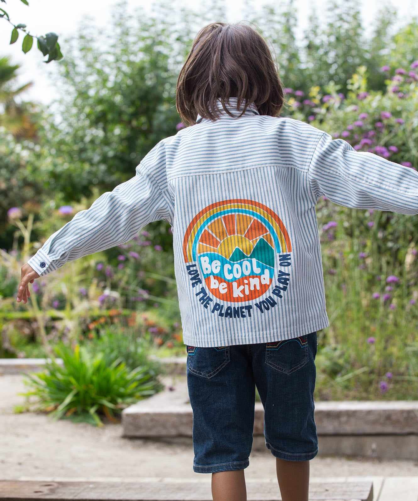 Frugi kids shacket, shirt with blue and white stripes and rainbow design worn by a child