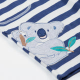 Close up of the Frugi kids sunny koala big stripe short showing an appliqué of a grey koala on the side on navy and white organic cotton fabric