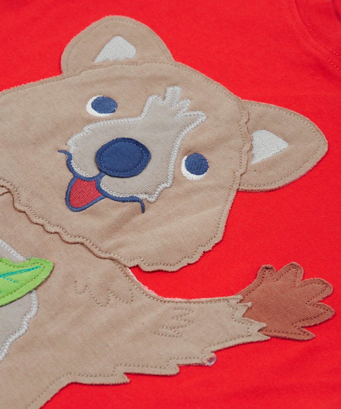 Close up of the Frugi kids strawberry quokka tshirt. Showing the brown quokka appliqué on red organic cotton fabric