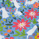 Close up of the Frugi kids watermelon iris bunny bottoms. Showing the different white rabbit and floral prints on light blue organic cotton fabric.