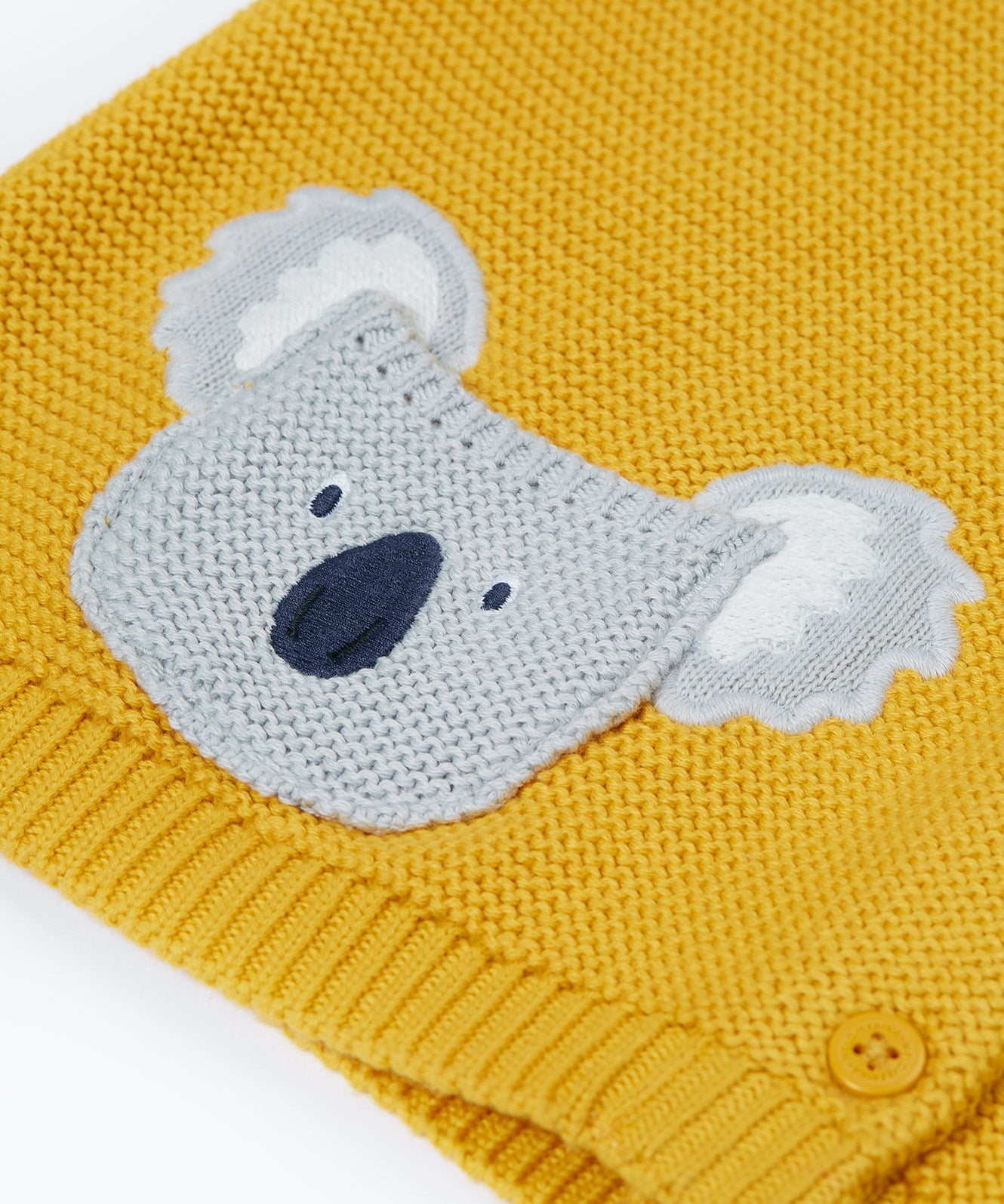 A close up of the organic knitted cotton grey koala bear pocket of the Frugi kids yellow koala cardigan 