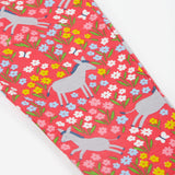 A close up of the Frugi kids donkey drove libby leggings. Showing the grey donkey and multicoloured flower design on light pink organic cotton fabric.