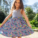 A child wearing the Frugi Summer Holiday Dress with a Lemur Laughs print design