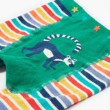 A close up of the Frugi baby lemur knitted leggings showing a navy lemur on a green panel on the front of the leggings on organic soft cotton fabric