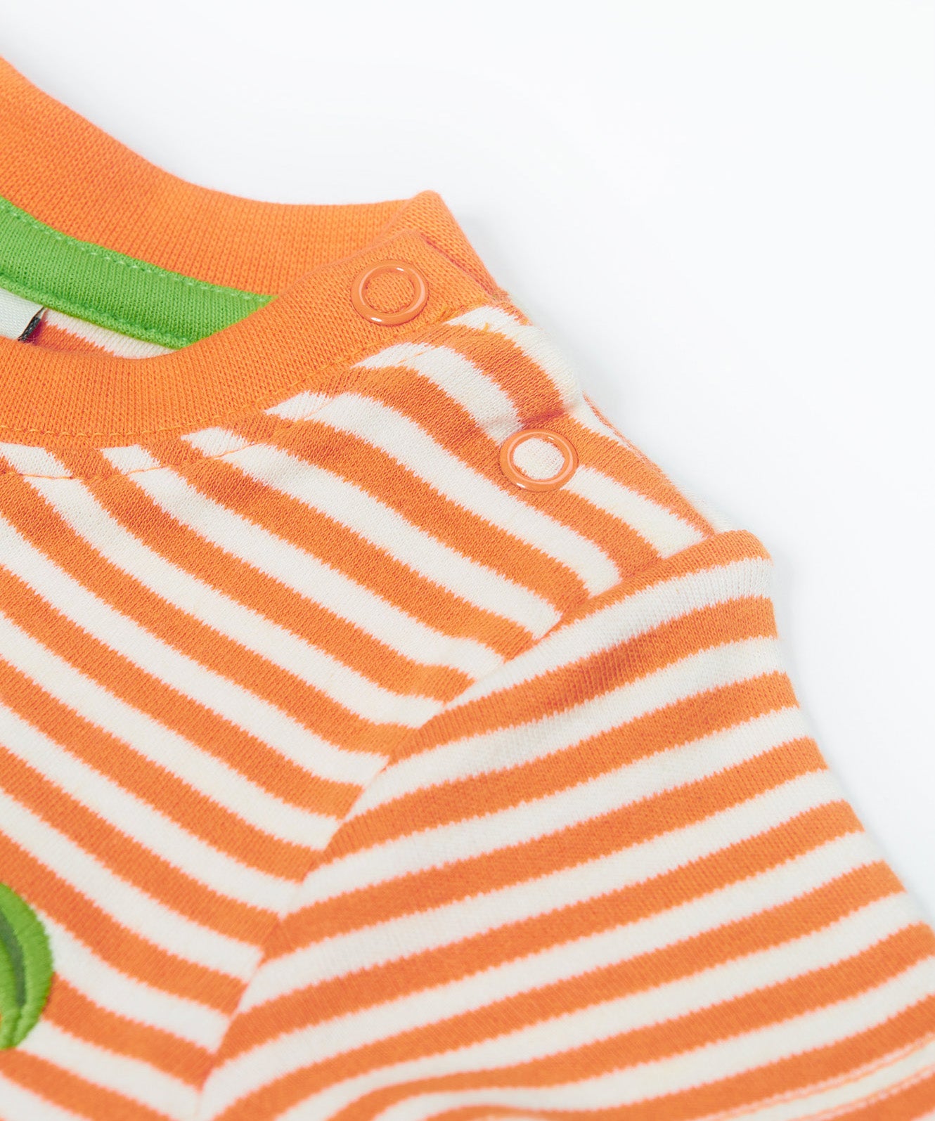 Close up of the the Frugi kids lifeboat stripe, apple t-shirt. Showing the popper fastener detail on orange and white striped organic cotton fabric 