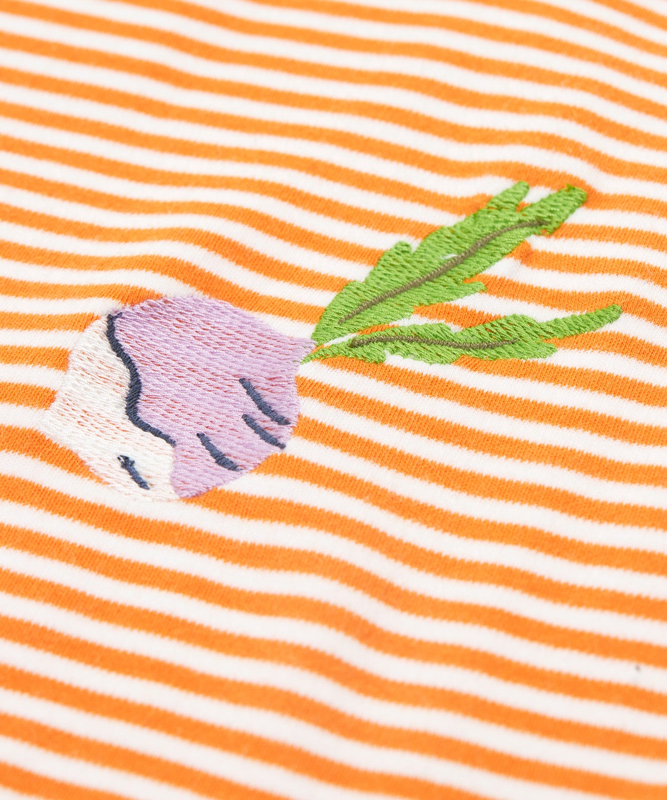 Close up of the Frugi kids lifeboat stripe veg t-shirt. Showing the purple radish appliqué on orange and white stripe organic cotton fabric