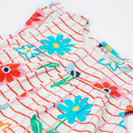 Close up of the Frugi baby Lula paint a floral playsuit. Showing the yellow bees and different coloured flowers on white and red check organic cotton fabric