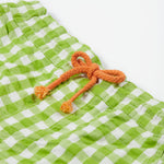 Close up of the Frugi kids macaw gingham Giles short showing the orange waist drawstring detail on green gingham organic cotton fabric