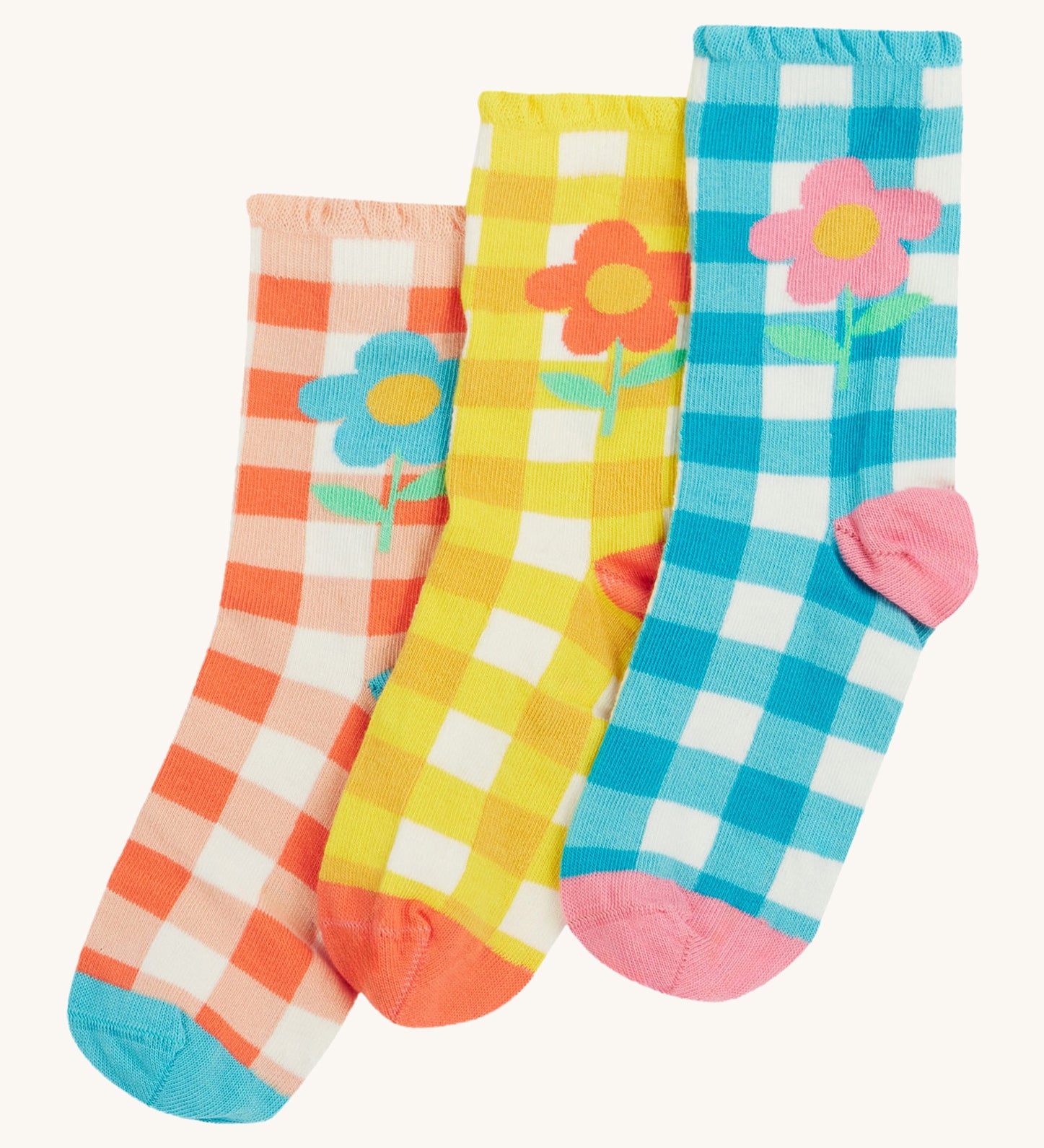 Frugi kids Freya frilled gingahm socks - GOTS organic cotton kids socks with a frilled cuff. Features a blue gingham with pink daisy sock, a yellow gingham with light orange daisy sock and a light orange gingham and blue daisy sock. 