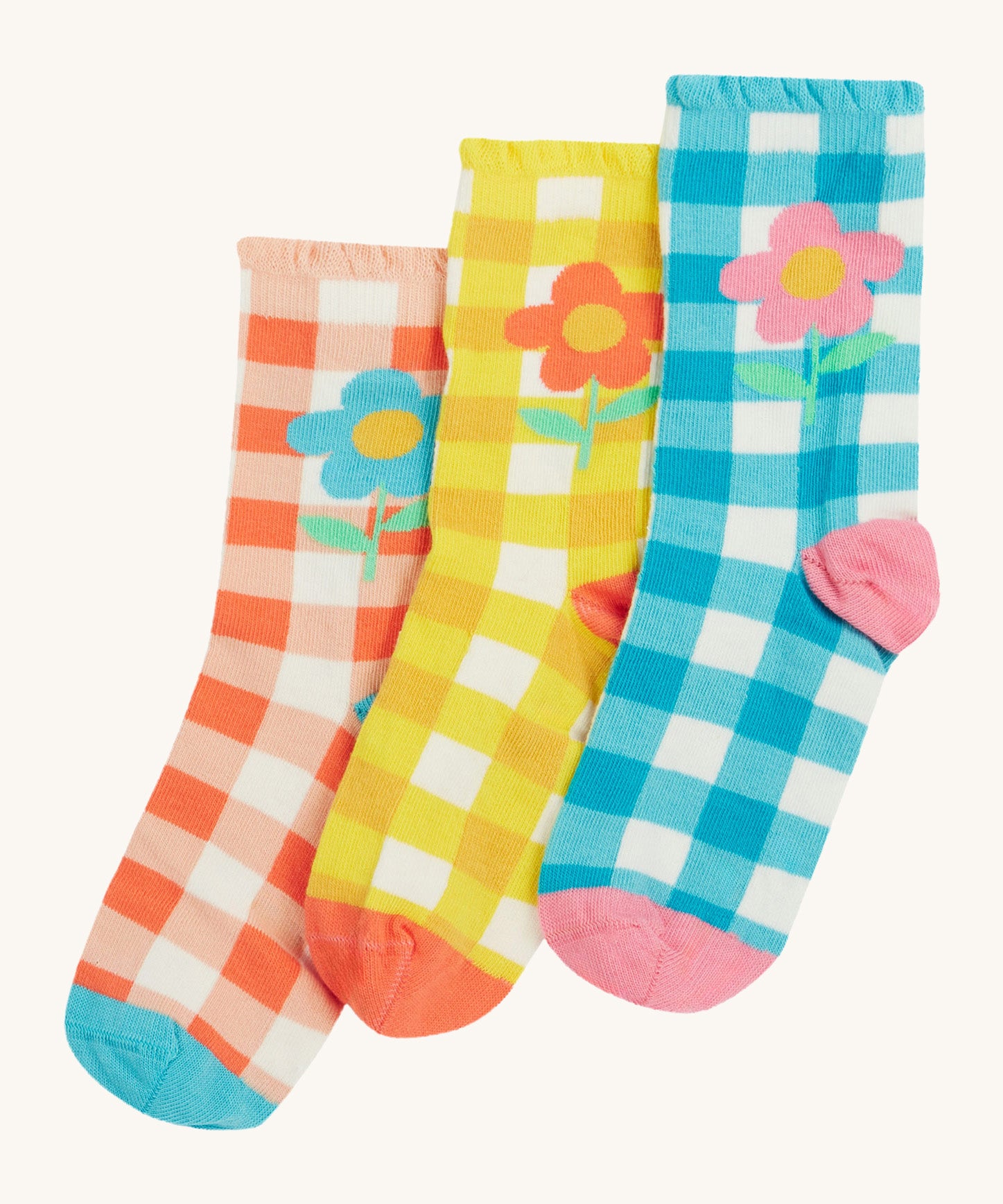 Frugi kids Freya frilled gingahm socks - GOTS organic cotton kids socks with a frilled cuff. Features a blue gingham with pink daisy sock, a yellow gingham with light orange daisy sock and a light orange gingham and blue daisy sock. 