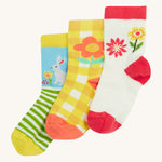 Frugi kids spring 3 pack socks - GOTS organic kids socks which features a white sock with a pink trim and flowers. A yellow gingham sock with a flower design and a green striped sock with a rabbit design.