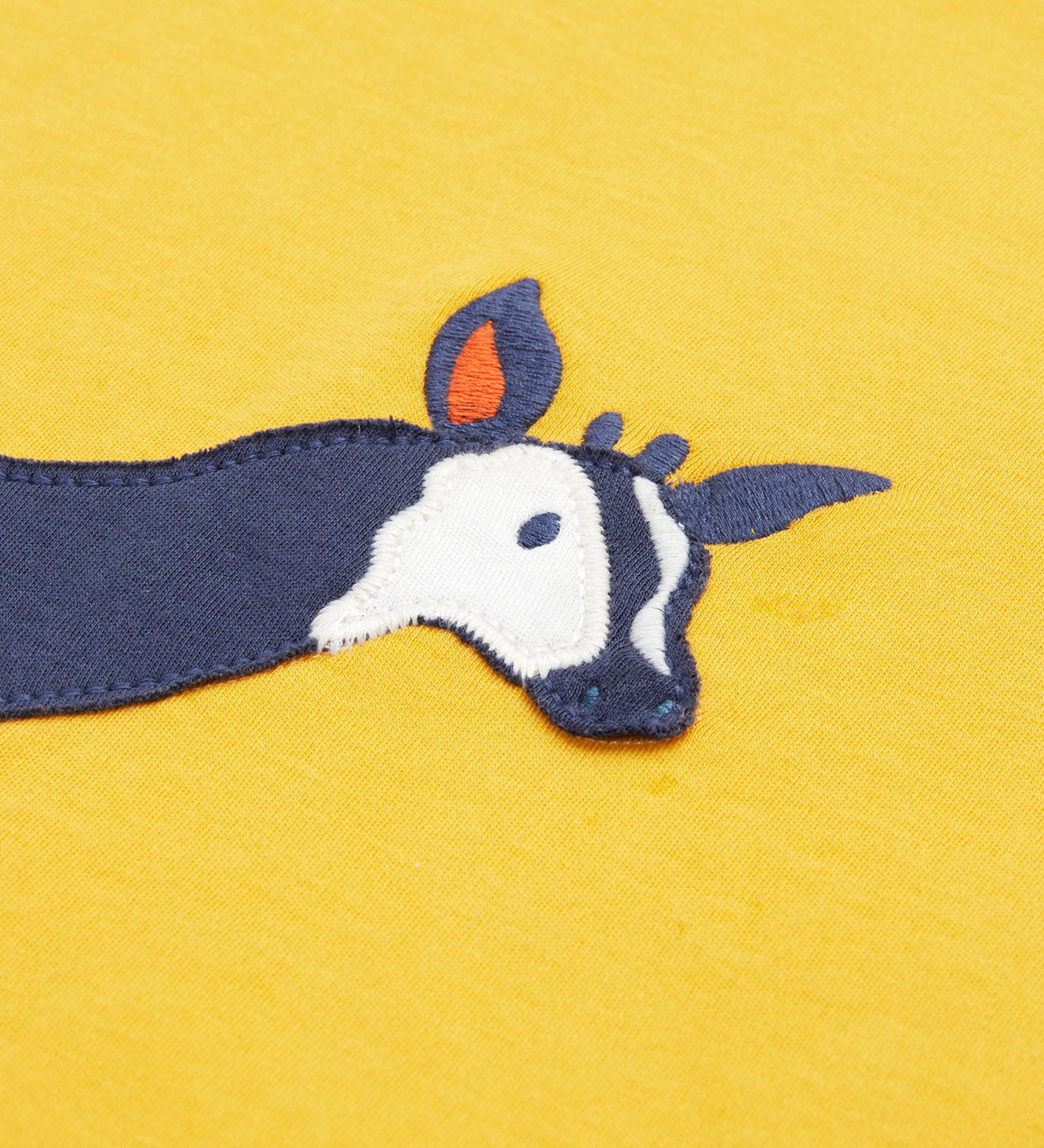 Close up of the Frugi kids bumblebee okapi short sleeve t-shirt. showing the head of the okapi animal appliqué on yellow organic cotton fabric