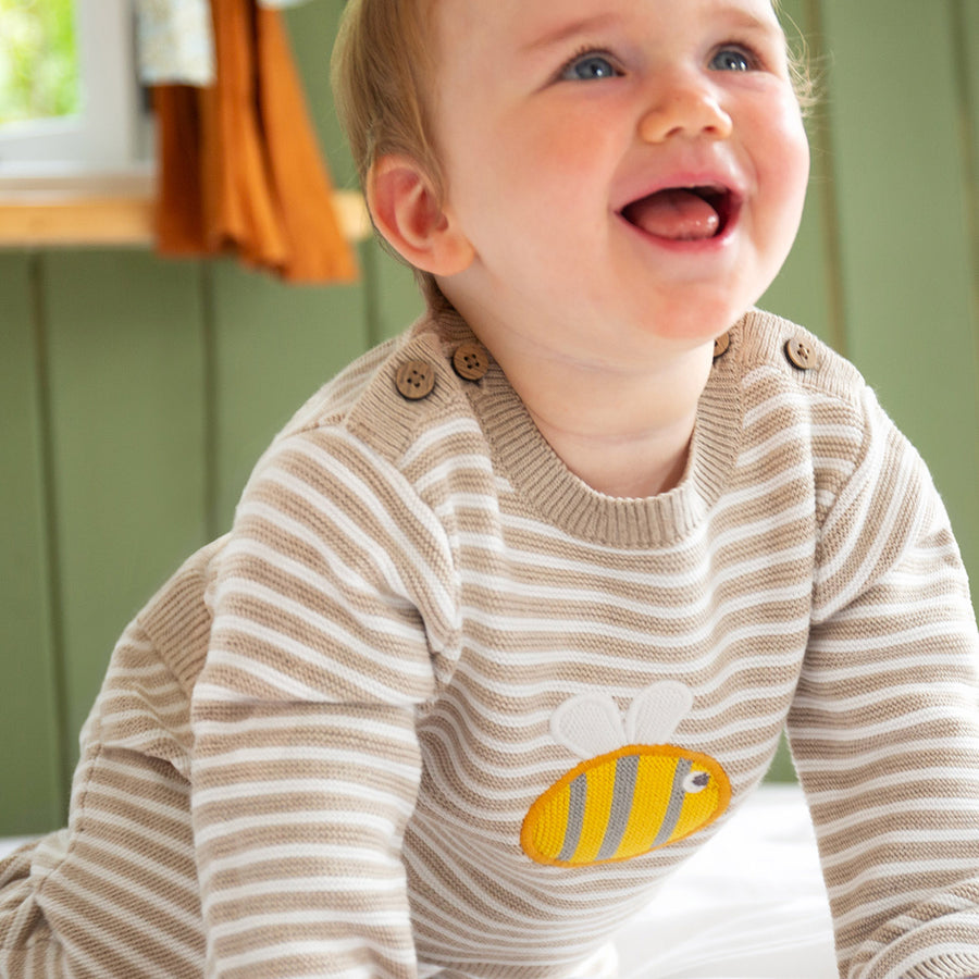 A baby wears the Frugi Knitted Outfit - Buzzy Bee.